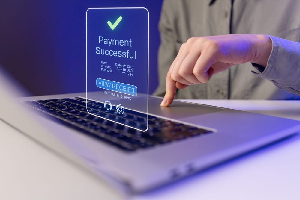 Person completing a secure online payment on a laptop with PCI compliant hosting protecting the transaction
